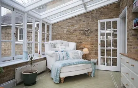Side conservatory on a house with a big white chair